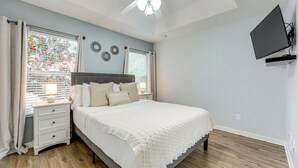 A bedroom with a bed, nightstands, a ceiling fan, and a TV mounted on the wall. - 2 Mi to Wdw: Townhouse w/ Patio & Pool Access (Kissimmee)