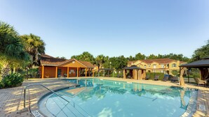A swimming pool with a tiled deck, surrounded by buildings and palm trees. - 2 Mi to Wdw: Townhouse w/ Patio & Pool Access (Kissimmee)