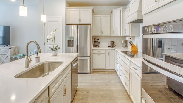 A modern kitchen with white cabinetry, stainless steel appliances, and a central island with a sink. - Pool + Shuttle to Ocean! North Myrtle Beach Escape (North Myrtle Beach)