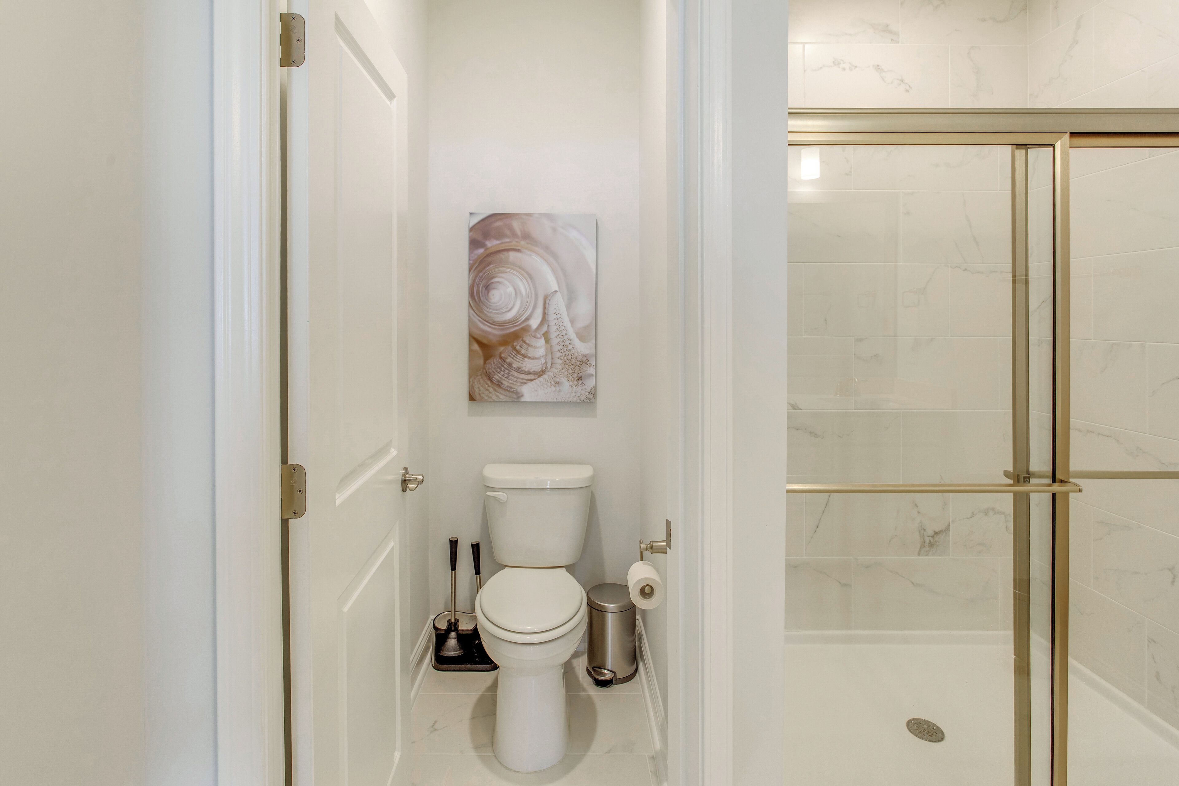 A bathroom with a toilet, a sink, and a shower area.