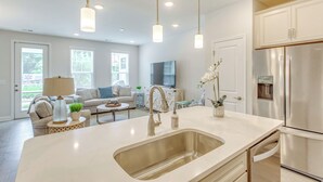A modern kitchen with a large island, stainless steel appliances, and pendant lighting. - Pool + Shuttle to Ocean! North Myrtle Beach Escape (North Myrtle Beach)