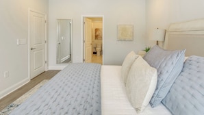 A bedroom with a large bed, a bedside table, and a nightstand. - Pool + Shuttle to Ocean! North Myrtle Beach Escape (North Myrtle Beach)