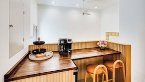 A kitchen with a wooden countertop, a coffee maker, a bowl, and a vase with flowers. - Shop, Dine & Walk to Ocean: Redondo Beach Apt! (Redondo Beach)