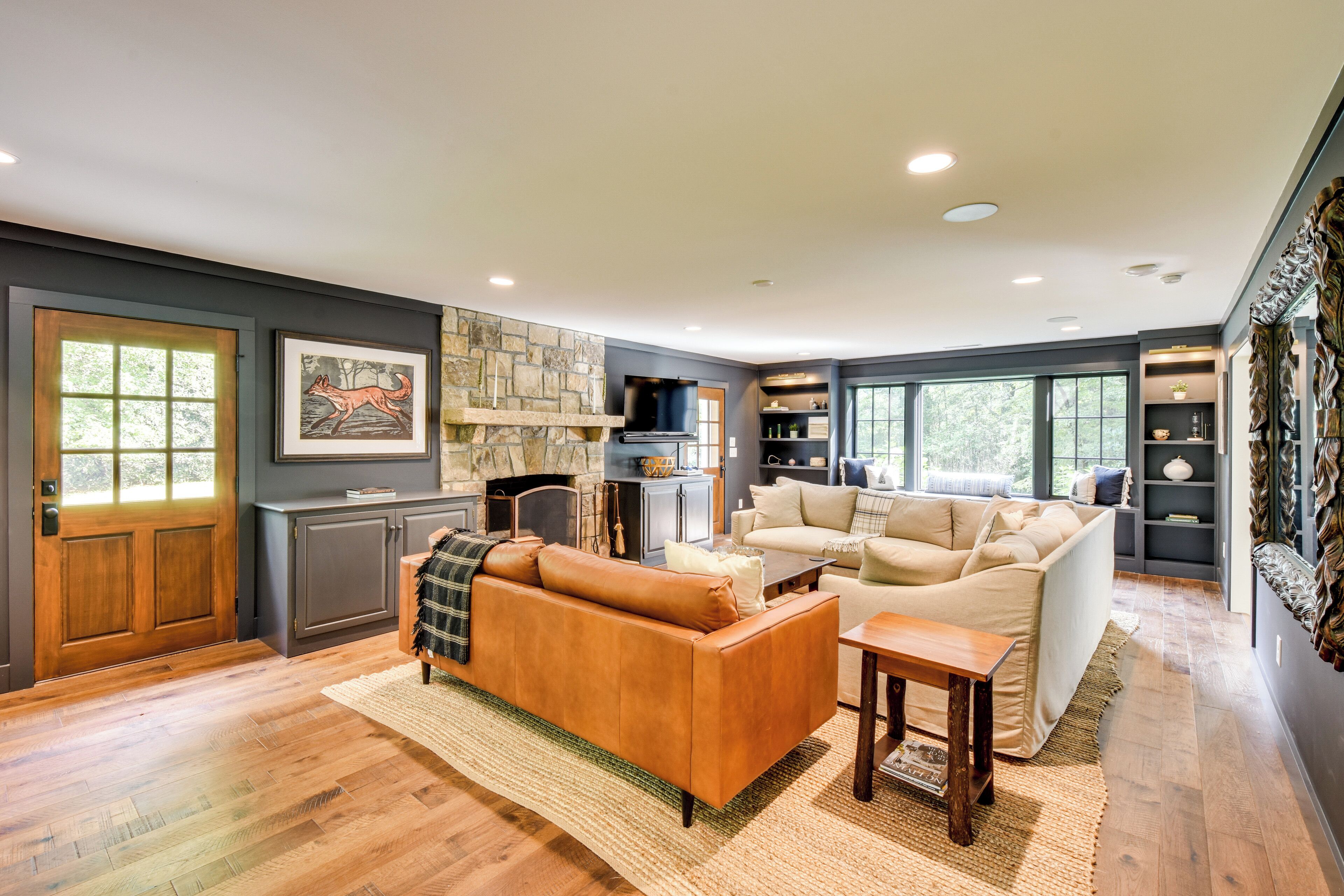 A modern living room with a fireplace, a sofa, a coffee table, and a dining area.