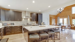A spacious kitchen with a large island, dark cabinets, and a wooden ceiling. - Hot Tub, Game Room! 3-story Brian Head Home (Brian Head)