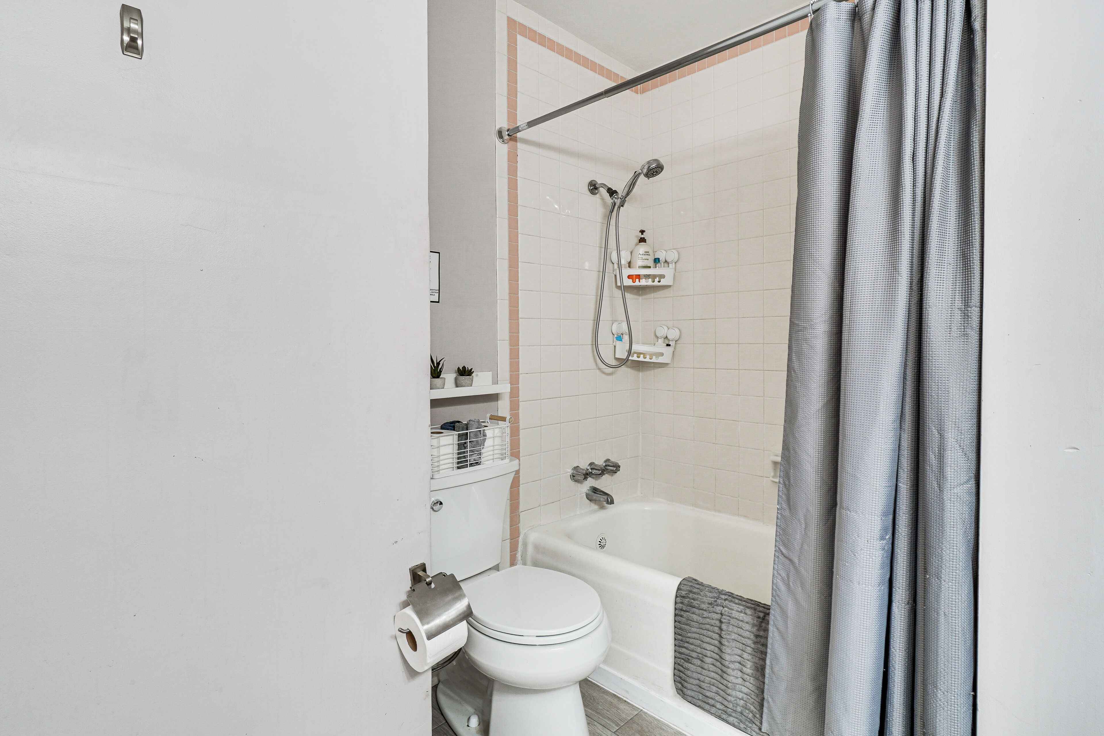 A bathroom with a toilet, a shower with a glass door, and a bathtub.