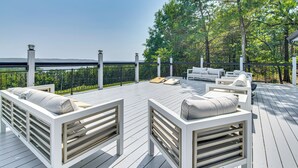 A deck with white furniture, including sofas and a coffee table, overlooking a body of water. - Lake View & Game Room on 3 1/2 Acres, Near Marina (Kimberling City)