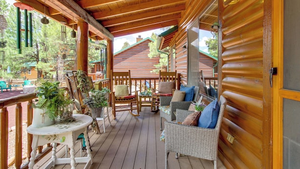 Une terrasse en bois, agrémentée de meubles en osier et de plantes en pot.