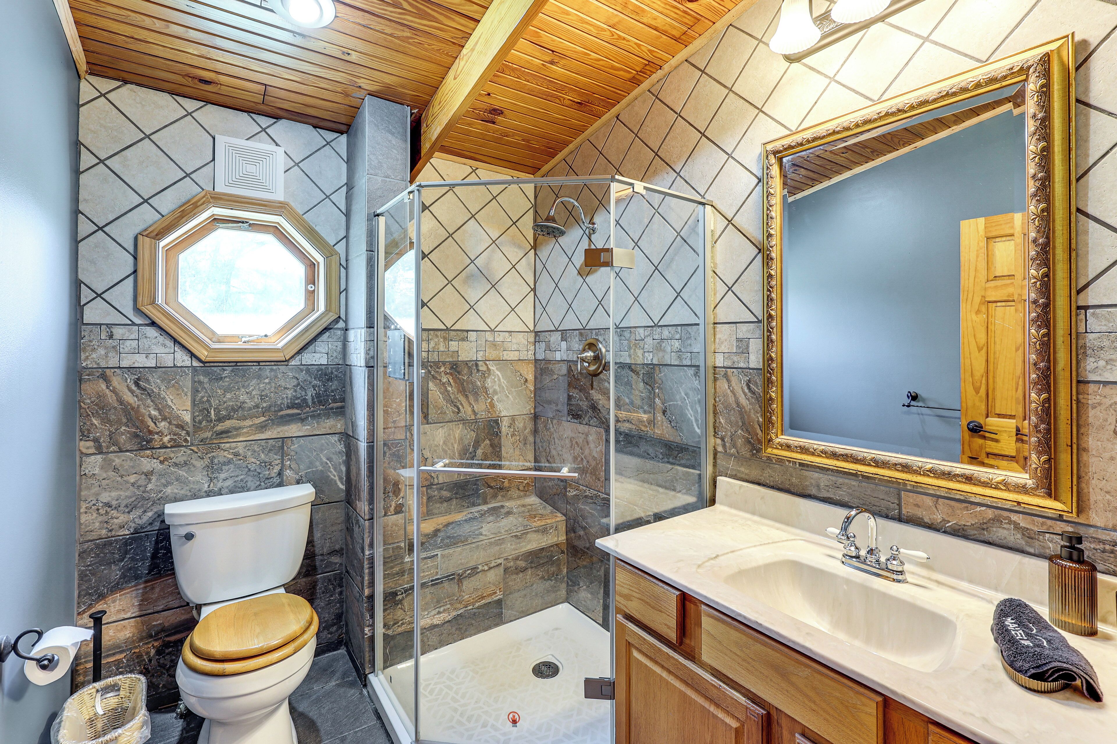 A bathroom with a shower, toilet, and sink.