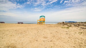 A beach with a lifeguard tower, picnic tables, and a rocky area. - Home < 1 Mi to Lake Erie & Shades Beach Park! (Harborcreek)