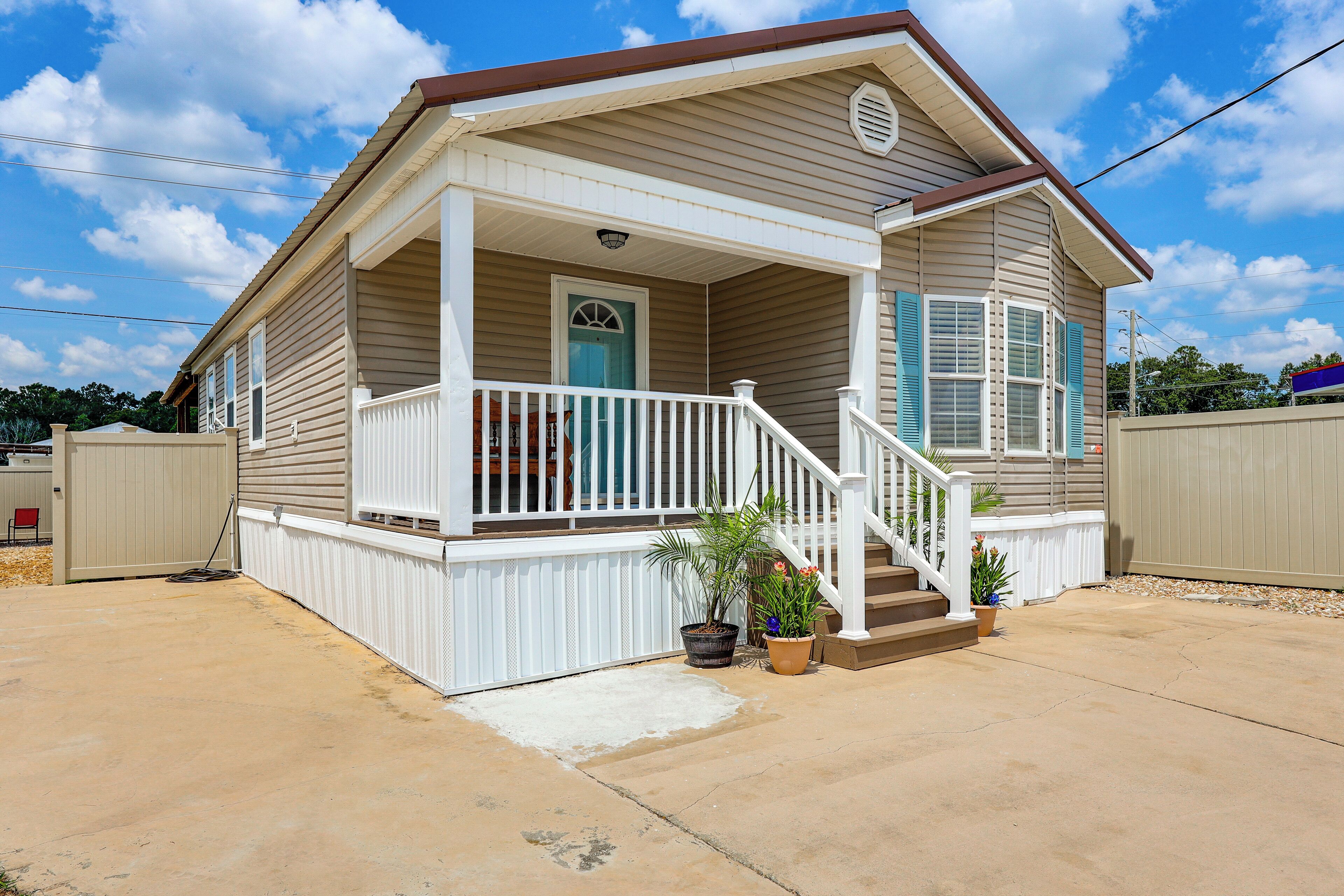 A single-story house with a covered porch, a front door, and a small set of stairs leading to the entrance.