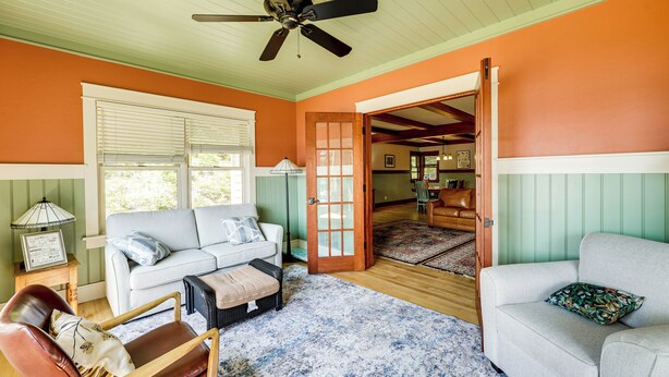 A living room with a sofa, a chair, a coffee table, and a ceiling fan. - Lakefront Hamlin Home w/ Fire Pit & Dock (Free Soil)