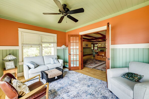 A living room with a sofa, a chair, a coffee table, and a ceiling fan. - Lakefront Hamlin Home w/ Fire Pit & Dock (Free Soil)