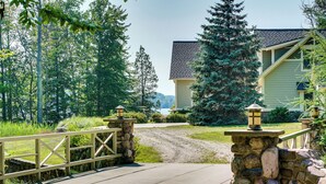 A stone bridge leading to a house with a stone foundation and a light-colored exterior. - Lakefront Hamlin Home w/ Fire Pit & Dock (Free Soil)