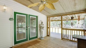 Un patio in legno con un ventilatore a soffitto, una targa di benvenuto e una statua.