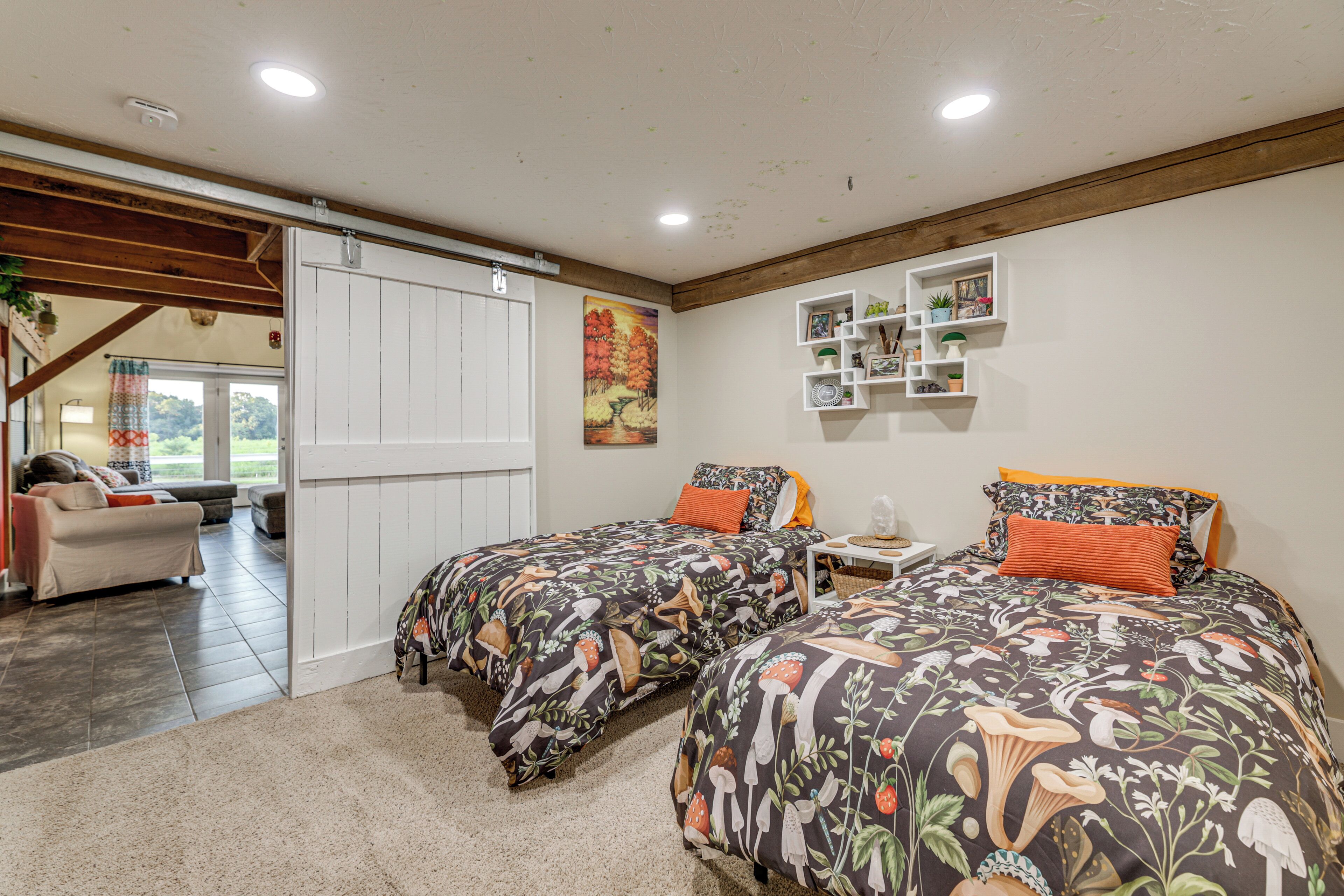 A bedroom with two beds, a large window, and a view of the outdoors.