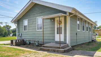 A single-story house with a front porch, a small front yard, and a visible air conditioning unit.