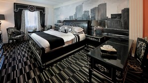 A hotel room with a large bed, a cityscape mural, a desk, and a chair. - House of splendor Boutique Hotel (Lagos)