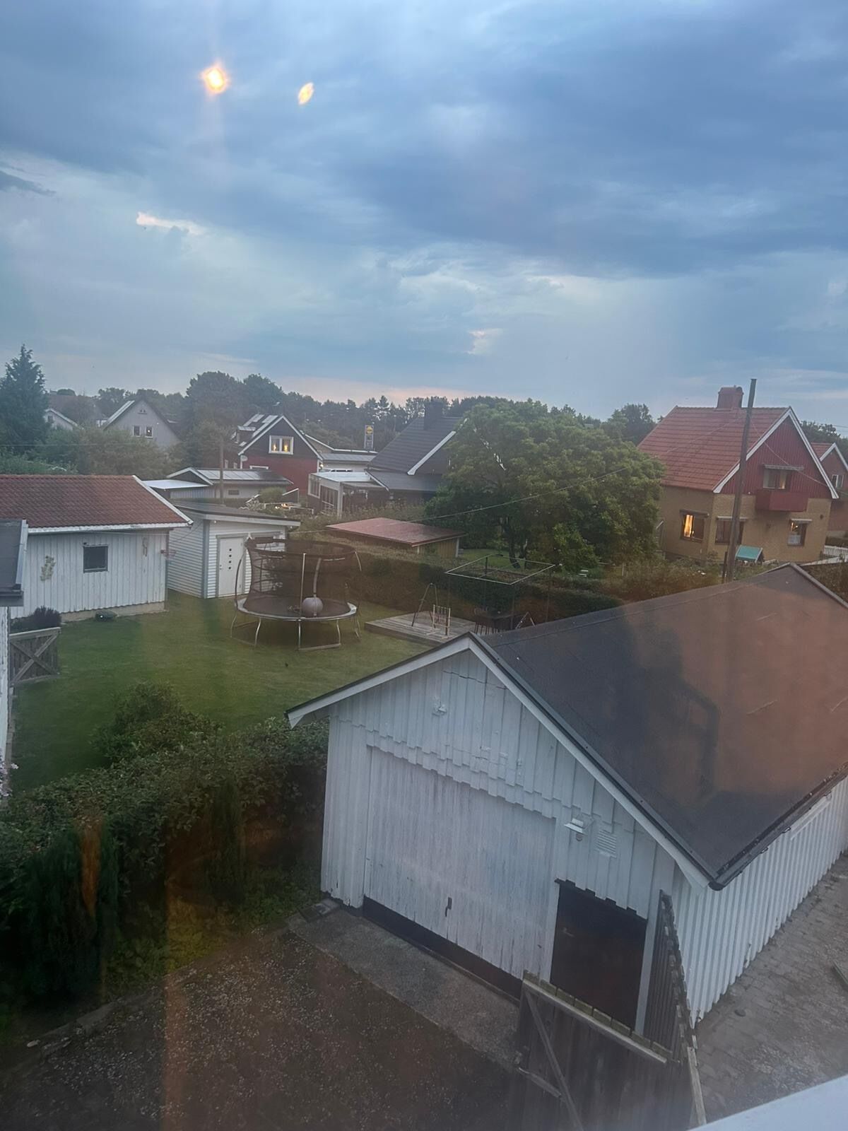 Un quartiere residenziale con case, un cortile recintato e un edificio con un ampio garage.