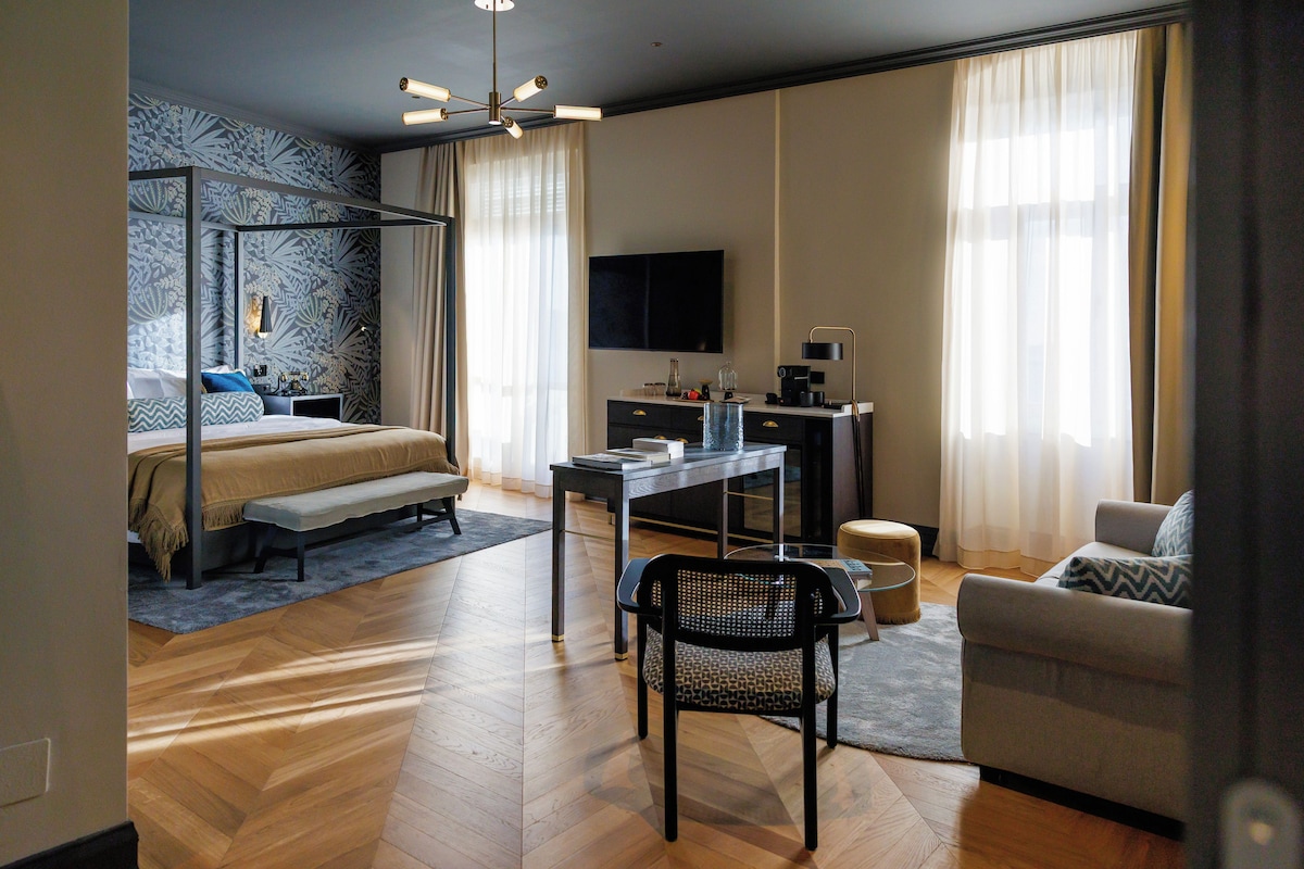 Una habitación de hotel moderna con cama, escritorio, silla y televisión.