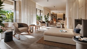 A spacious living area with a sofa, chairs, and a coffee table. There is a fireplace and a bookshelf in the background. - Jadran Heritage Hotel Valamar Collection (Poreč)