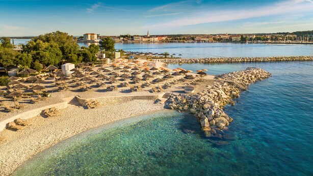 A beachside resort with clear waters, sun loungers, umbrellas, and a rocky shoreline. - Jadran Heritage Hotel Valamar Collection (Poreč)