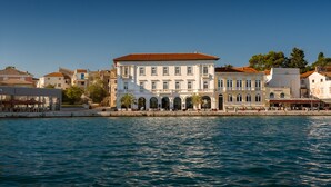 A waterfront building with multiple floors, balconies, and a red-tiled roof. - Jadran Heritage Hotel Valamar Collection (Poreč)
