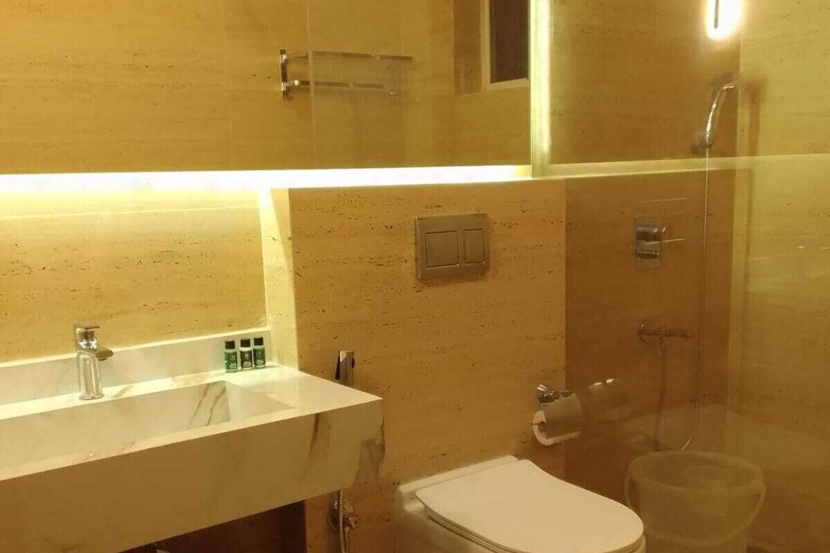 A modern bathroom with a white sink, mirror, and toilet.