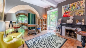 Ein Zimmer mit Kamin, einem Zebra-Teppich, einem Bücherregal und einem Bild an der Wand.