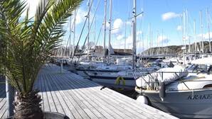 A marina with multiple sailboats docked, a wooden deck, and a palm tree. - Charming house with kayaks, 300m from the sea on Orust | SE09139 (Henån)