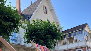 A hammock in a grassy area with a building in the background.
