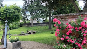 A garden with a brick wall, gravel path, and a water feature.