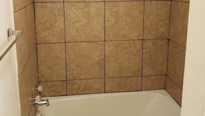 Un baño con bañera, ducha e inodoro.