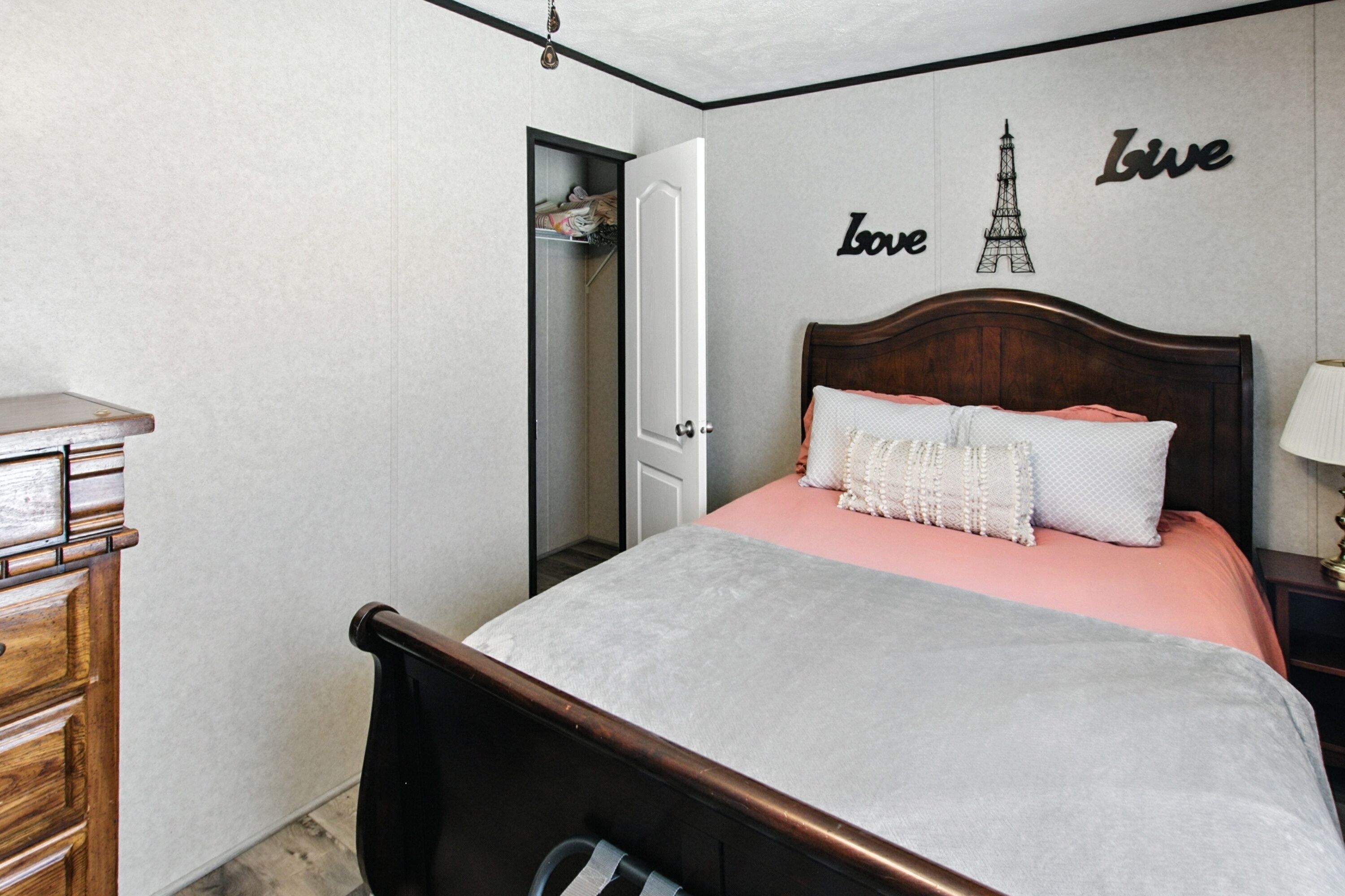 Une chambre à coucher avec un lit, une commode et une armoire.