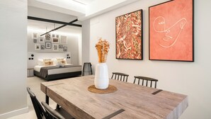 A modern dining area with a wooden table, a white vase with dried flowers, and two framed artworks on the wall. - Dobo Madrid Cabrera (Madrid)