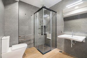 A modern bathroom with a glass-enclosed shower, a white sink, and a toilet. - Dobo Madrid Cabrera (Madrid)