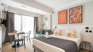 A modern hotel room with a bed, a desk, and a dining area. - Dobo Madrid Cabrera (Madrid)