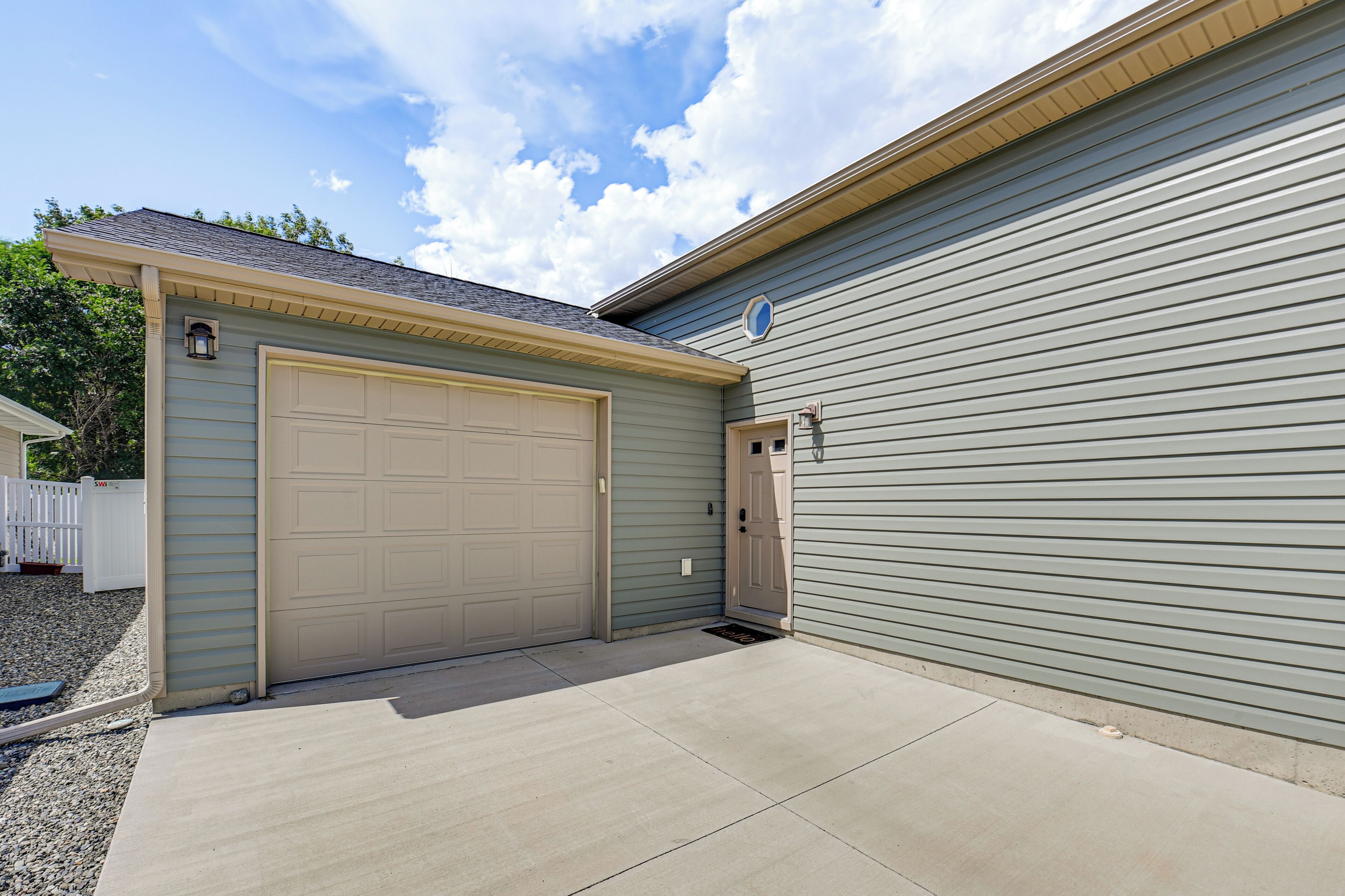 A residential garage with a beige door and a small window.
