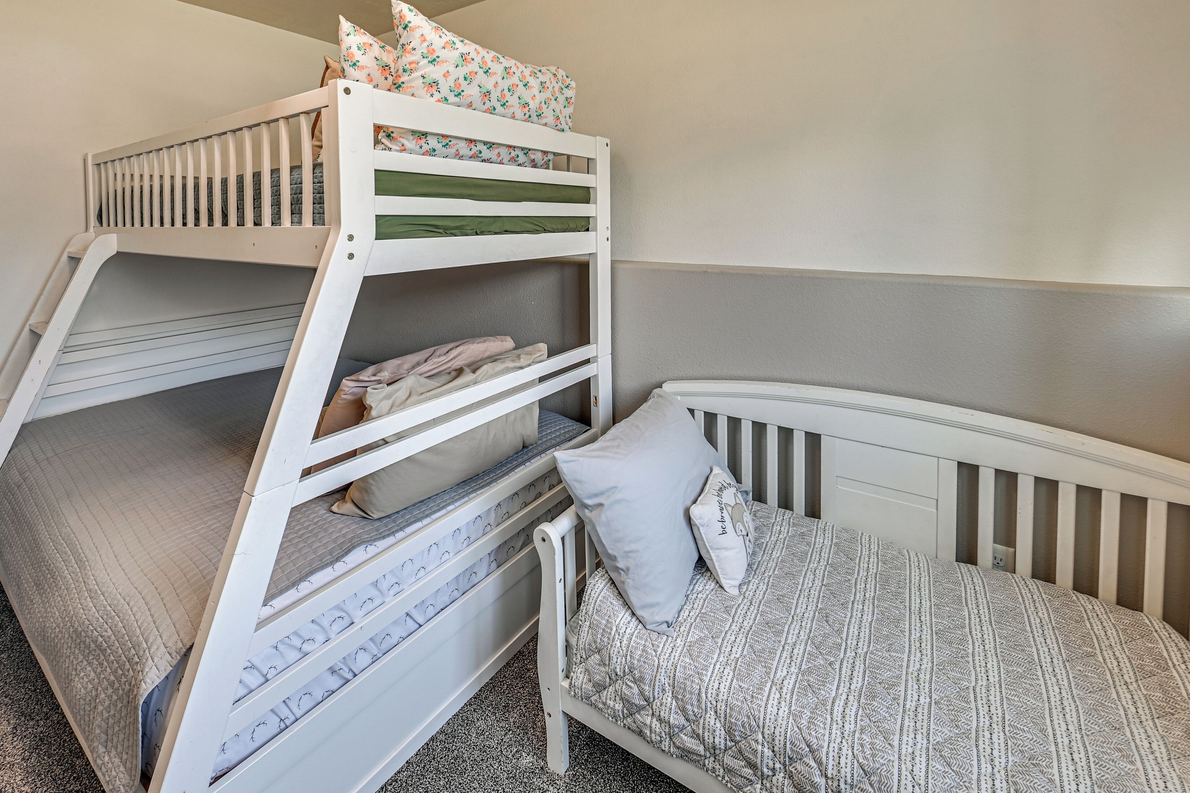 A bunk bed with a lower bunk and a single bed, both with patterned bedding.