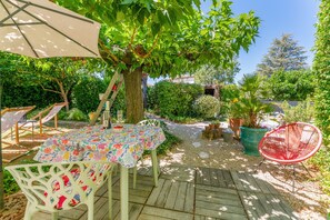 A wooden deck with a table and chairs, surrounded by potted plants and a tree. - Holiday Home 'Jardin' with Shared Pool, Private Terrace and Wi-Fi (L'Isle-sur-la-Sorgue)