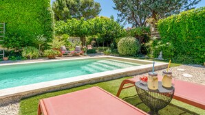 A swimming pool with a patio area, surrounded by lush greenery and trees. - Holiday Home 'Jardin' with Shared Pool, Private Terrace and Wi-Fi (L'Isle-sur-la-Sorgue)