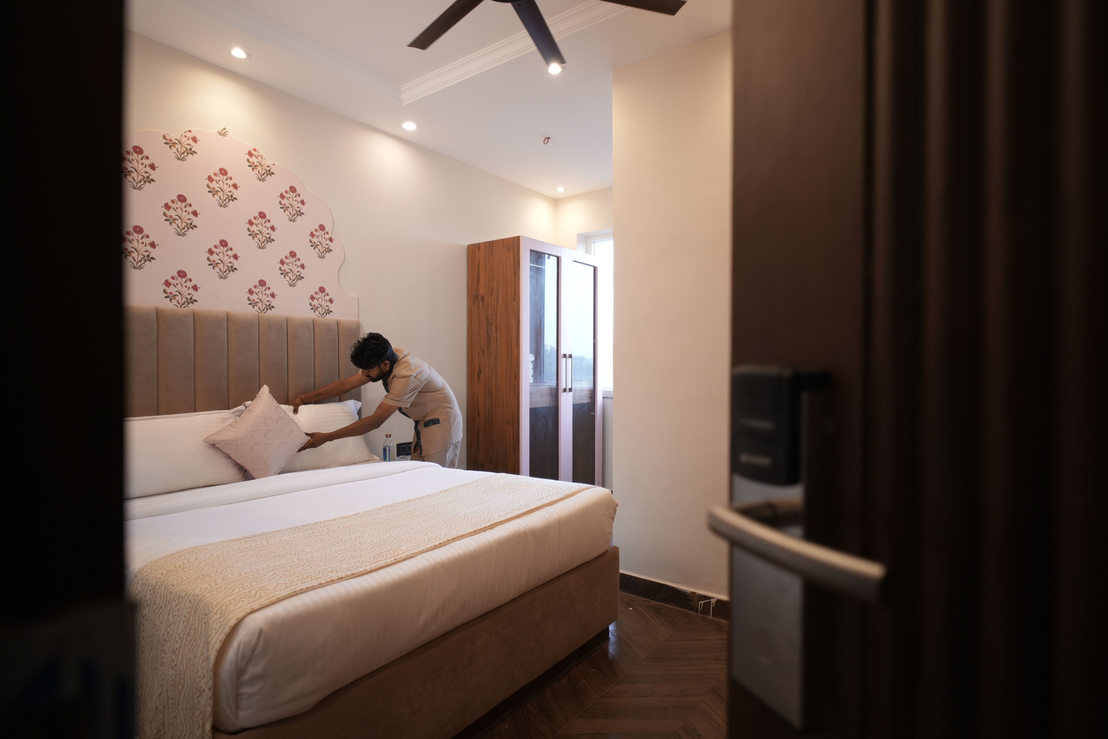 A hotel room with a large bed, a wardrobe, and a television.