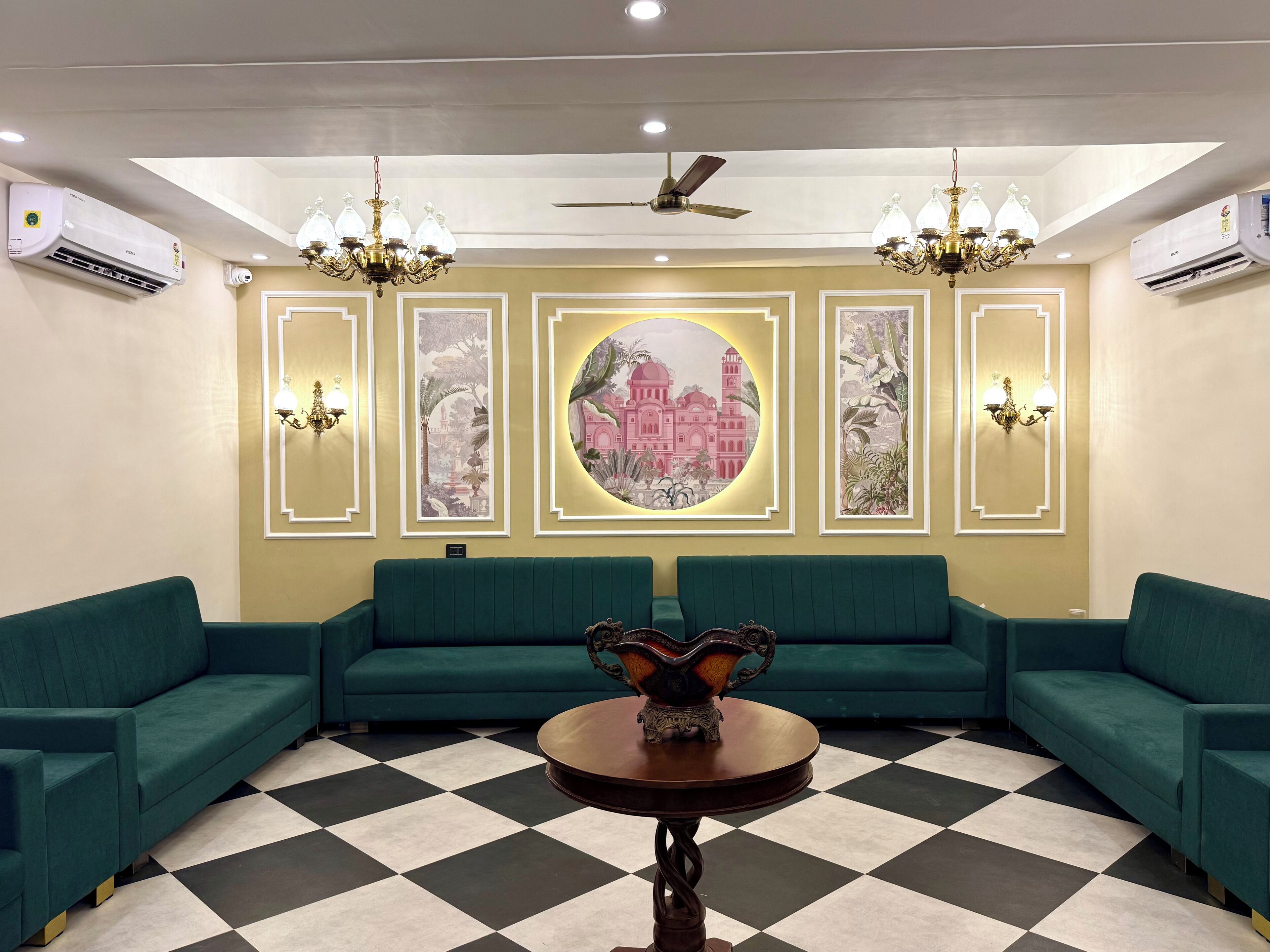 A lobby with teal sofas, a checkered floor, and wall-mounted air conditioning units.