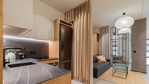 A modern kitchen with a built-in stove, a stainless steel refrigerator, and a marble countertop. - Dobo Madrid Goya (Madrid)