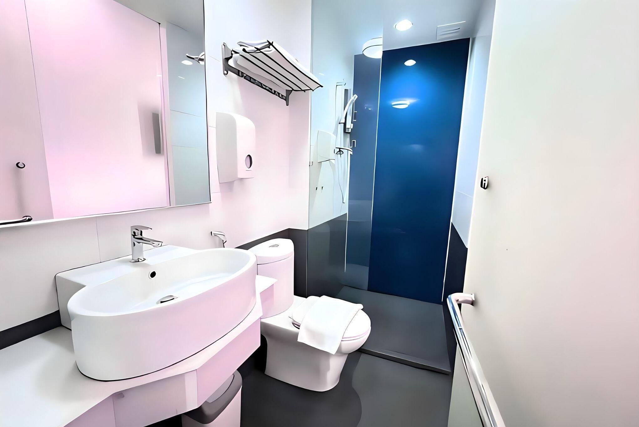 A modern bathroom with a large white sink, a toilet, and a shower area.