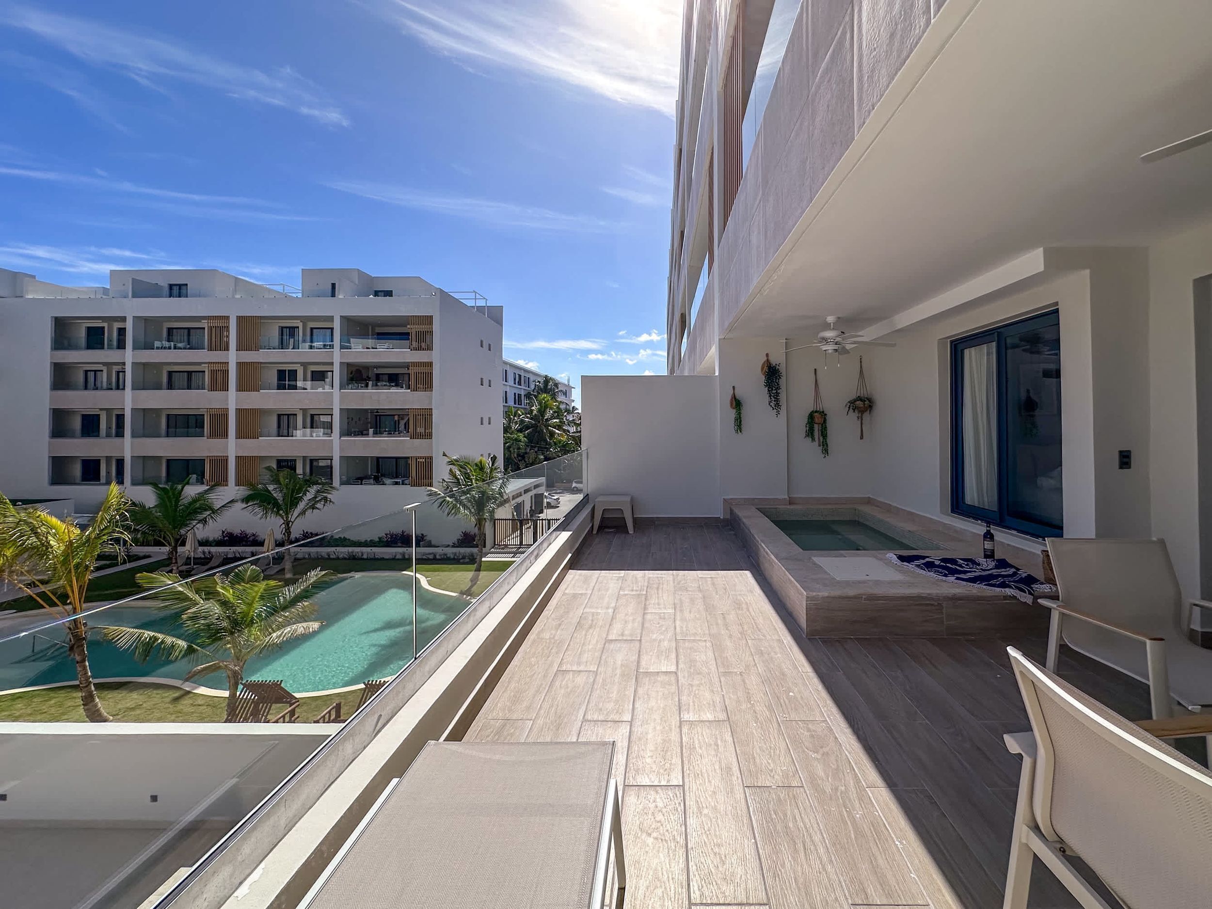 Varanda com piscina, área de estar externa e vista para outros edifícios.