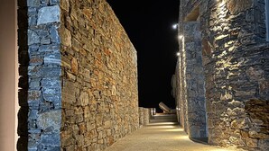 A stone corridor with a pathway leading to a seating area. - Pentanemi Folegandros (Folegandros)