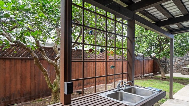 A covered outdoor area with a built-in sink and a wooden deck. - Architectural Gem With Infinity Pool Ocean Views - Vrkcv (Kailua-Kona)