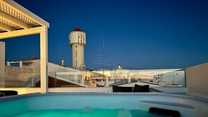 Een dakzwembad met een helder uitzicht op een watertoren en industriële gebouwen op de achtergrond.