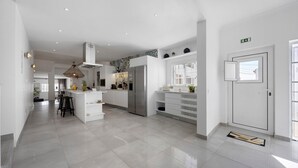 Een ruime keuken met een centraal eiland, roestvrijstalen apparatuur en een modern design.